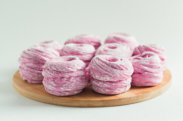 Obraz premium Pink marshmallow in the wooden plate on the white background