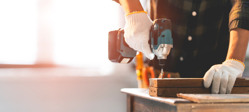 Male Mechanic Using A Cordless Screwdriver Drill With Wood Screws In The Workshop.