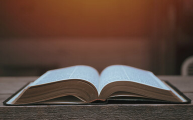 Open Bible on a wood table with light coming from above. ( Church concept. )