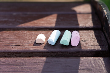 Colorful chalk sticks on park bench. Kids drawing chalks.