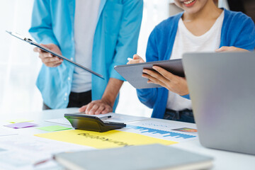 Young Asian colleagues discuss creative projects during the workflow. Business conversation starter idea for a modern friend meeting.