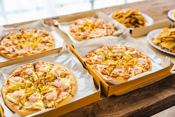 Desk of pizza party, crispy, french fry and white wine glasses wear on old weathered wooden desk in business office.