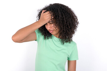 Fototapeta na wymiar A very upset and lonely Young beautiful girl with afro hairstyle wearing green t-shirt over white background crying,