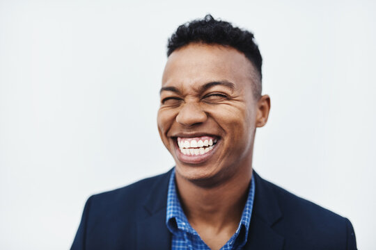 Im the happiest man in the whole world. Studio shot of a young businessman smiling and in good spirits against a grey background.