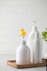 Blank plastic dispenser bottles with soap and shampoo for everyday in bathroom. Toiletries set