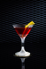Delicious cocktail with alcohol served with garnish prepared by the bartender in the cocktail bar in dark colors