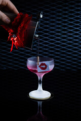 Delicious cocktail with alcohol served with garnish prepared by the bartender in the cocktail bar in dark colors