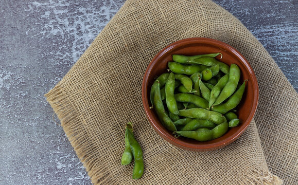 Edamame On Brown Bowl And Cloth, Overhead View