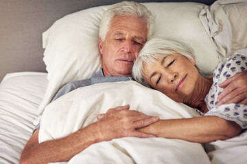 Moments like this are priceless. Shot of a senior couple sleeping in bed.