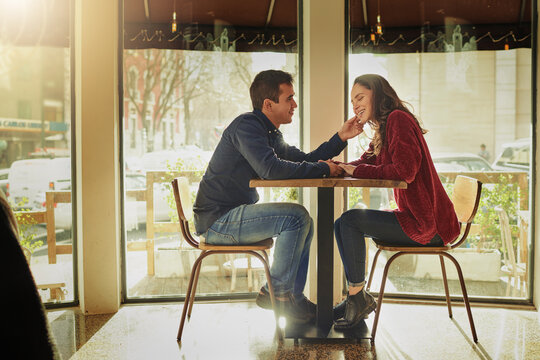 Theres always room for romance. Shot of a young man and woman on a romantic date at a coffee shop.
