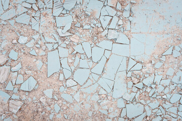 Broken ceramic tiles on the ground texture background. Crashed, shattered and cracked dirty blue stone tiles surface. Multiple mosaic pieces. Light, pastel, creative backdrop
