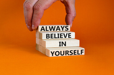 Always believe in yourself symbol. Concept words Always believe in yourself on wooden blocks on beautiful orange background. Businessman hand. Business motivational always believe in yourself concept.