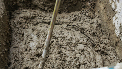 Mixing tile adhesive or cement with a power drill for repair works on construction site. Waiting to be mixed with cement.