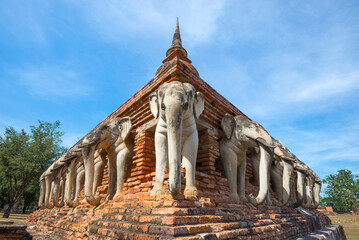 Restored elephant sculptures at the base of the old stupa of the Buddhist temple of Wat Sorasak on a sunny day. Sukhotai, Thailand