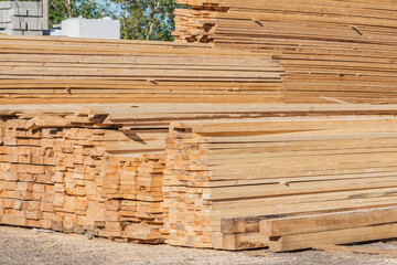 Pine wood timber stack of natural rough wooden boards.