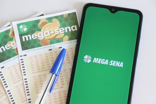 Bahia, Brazil - June 16, 2021: Mega Sena lottery logo on smartphone screen. Brazilian Lottery of Caixa Econ&ocirc;mica Federal - Loterias Online.