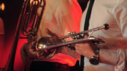 Close-up of a trumpet player standing on stage with musicians in the background