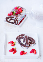 Chocolate roll with white cream and fresh strawberries for tea
