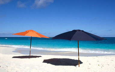 Two umbrellas on white sand beach in Nassau, Bahamas