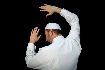 Muslim man standing and praying in the front of Kaaba in Mecca, KSA
