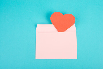 Pink envelope with a red heart, empty copy space, blue background, valintines day greeting card, romantic mail, love letter