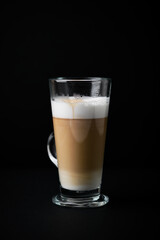 Coffee with milk on dark background. Close up. Copy space.