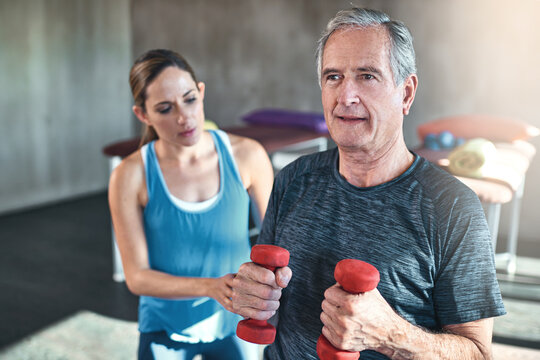 Maintaining Muscle Mass With Regular Exercise. Shot Of A Senior Man Working Out With His Physiotherapist.