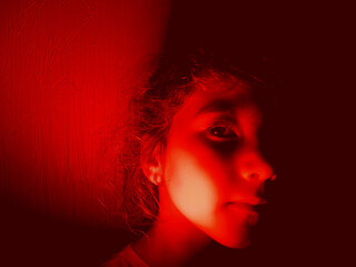 portrait of little girl in red light.