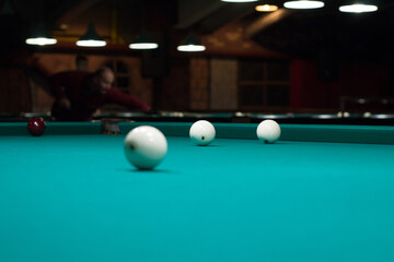 Russian billiards in club: white balls on green table cloth