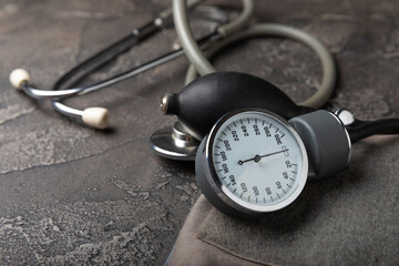 Black blood pressure monitor on a black marble background.Medical equipment blood pressure monitor.Health care. Place for text. Medicine concept. The concept of cardiology.