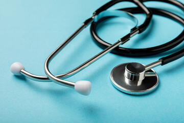 Black stethoscope on a blue background, closeup.Health care. Place for text. Medicine concept