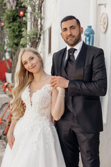 Vertical portrait cheerful and romantic married couple, blond woman, black-haired man on wedding ceremony. Holiday party