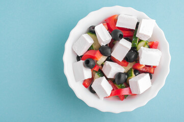 top view of greek salad on blue background