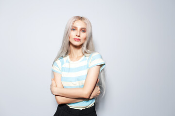 Studio portrait of cute blonde girl in striped shirt on white background.