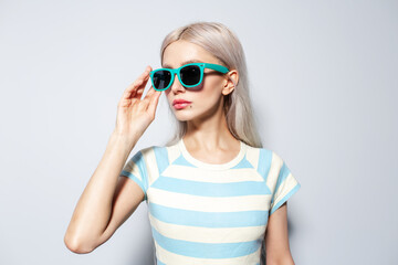 Portrait of pretty, fashion blonde girl in striped shirt on white background.