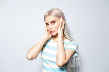 Portrait of pretty, fashion blonde girl in striped shirt on white background.