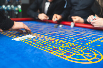 Vibrant casino table with roulette in motion, with casino chips, tokens, the hand of croupier,...