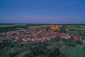 Drone image of Muenzenberg with illuminated castle ruins in Germany