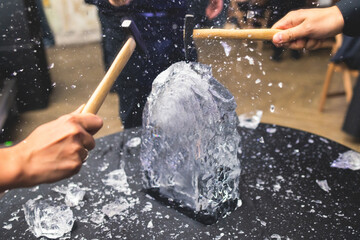 Process of breaking the ice with hammer and ice pick, group of people smashing shattered ice cube, team work success concept, concept of starting event, conversation - obrazy, fototapety, plakaty