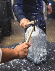 Process of breaking the ice with hammer and ice pick, group of people smashing shattered ice cube, team work success concept, concept of starting event, conversation