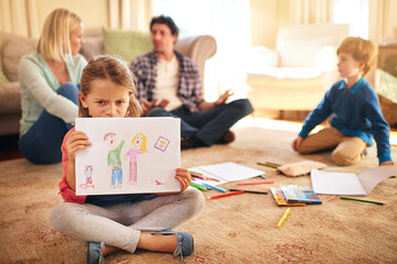 Caught in the middle of conflict. Portrait of an unhappy daughter holding a drawing depicting...