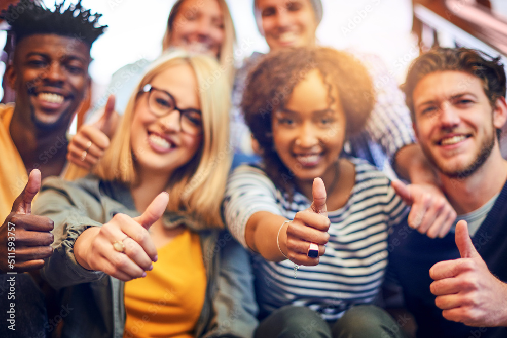 Aufkleber its a thumbs up to higher education. portrait of a group of diverse university students showing a th