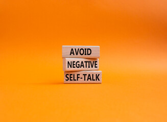Avoid negative self-talk symbol. Concept words Avoid negative self-talk on wooden blocks. Beautiful orange background. Business and Avoid negative self-talk concept. Copy space.