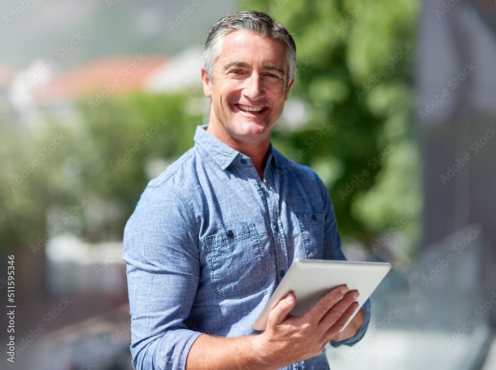 Aufkleber Wireless technology keeps my daily tasks streamlined. Portrait of a casually dressed businessman using a digital tablet outside.