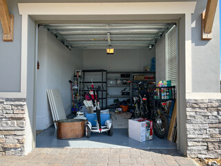 An unorganized garage filled with a lot of stuff in a neighborhood.