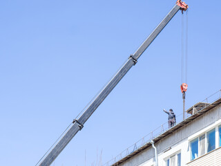 Obraz premium the builder works on the roof of the house, takes the load on the roof