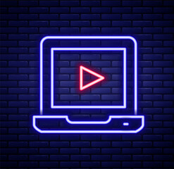 Glowing neon line Online play video icon isolated on brick wall background. Laptop and film strip with play sign. Colorful outline concept. Vector