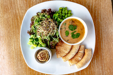 Beef goulage with garlic and pita bread and cutlery on a gray stone table