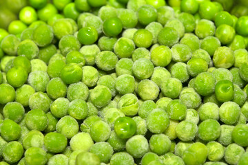 Partially defrosted frozen peas, macro food background
