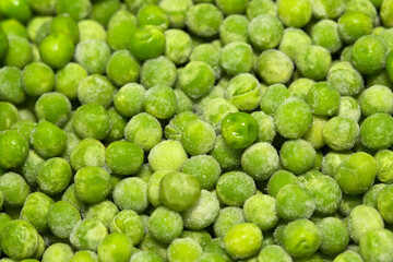 Partially defrosted frozen peas, macro food background
